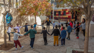 Children and teachers forming a circle in the school's courtyard