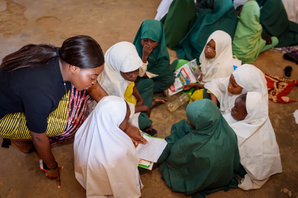A female teacher teaching children in an African school