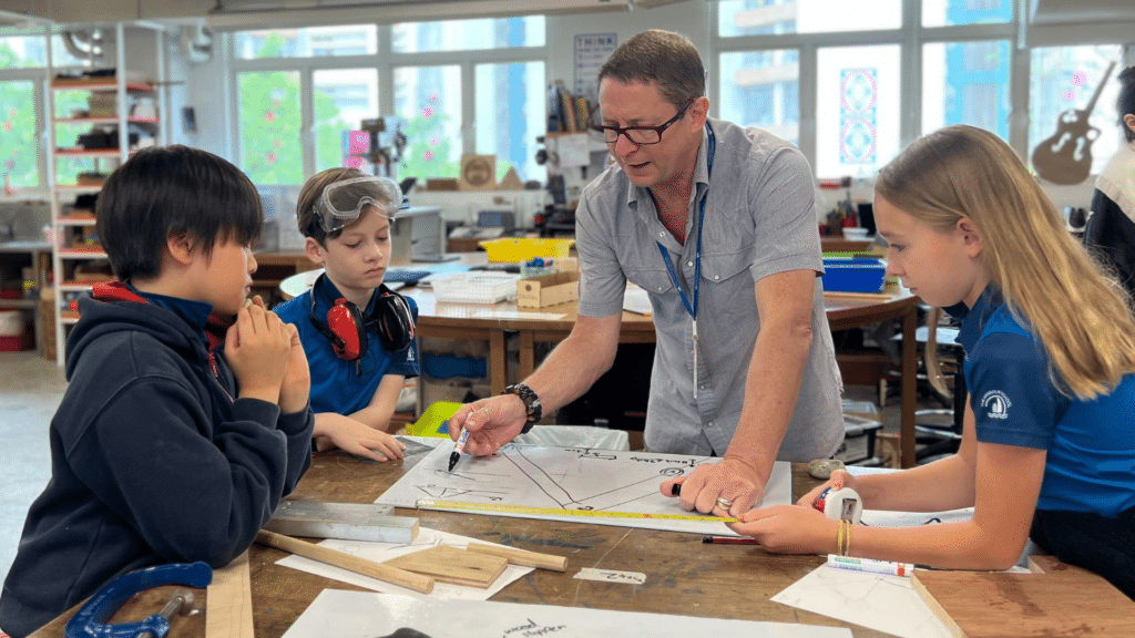 A teacher explaining a technical drawing to his students
