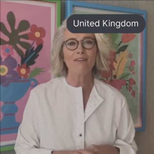 Dame Emma Thompson, speaking in front of a colorful floral painting.