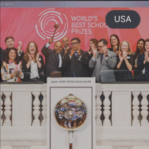 Group of people celebrating at the New York Stock Exchange for the World's Best School Prizes, with a large globe trophy displayed in the foreground.