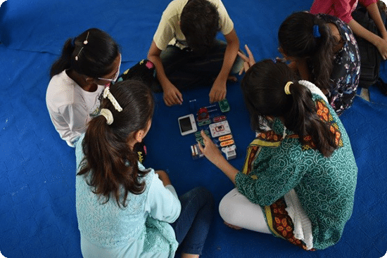Students engaged in a hands-on learning activity with electronics and educational kits
