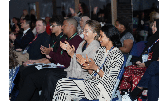 Audience members clapping and smiling during a session at the World Schools Summit, showing appreciation for the discussion.
