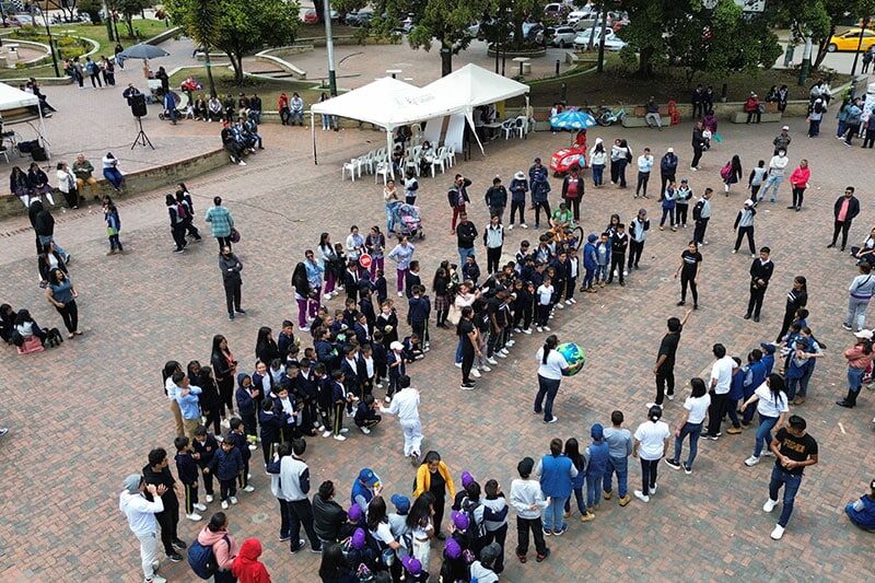 Large group of students and teachers gathered in a public plaza participating in an outdoor educational or community event