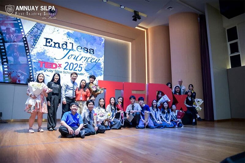 Group of students and speakers posing on stage after a TEDx 2025 event at Amnuay Silpa School, with a large TEDx sign and backdrop reading “Endless Journey”