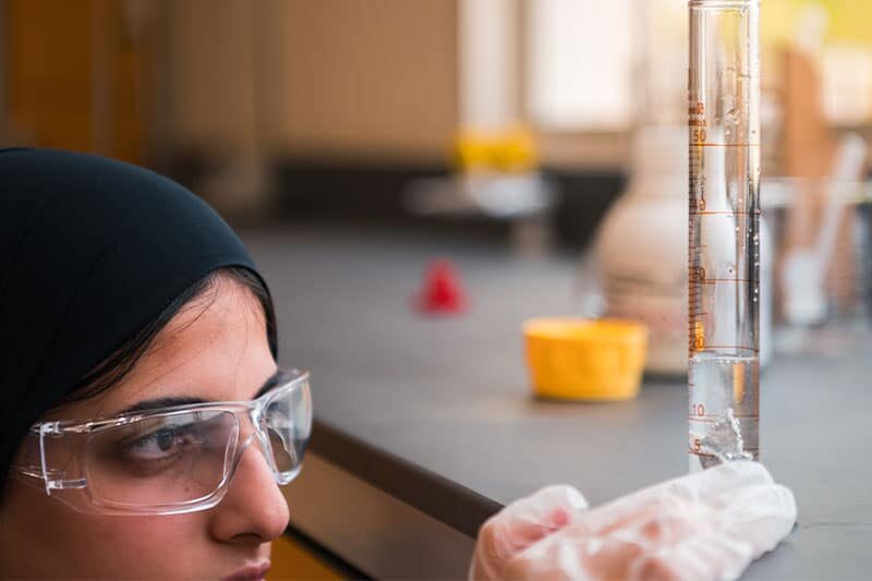 Focused ATS UAQ student carefully observing a measurement cylinder during a science activity