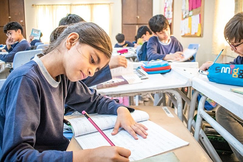 Older students focused on writing during a classroom activity