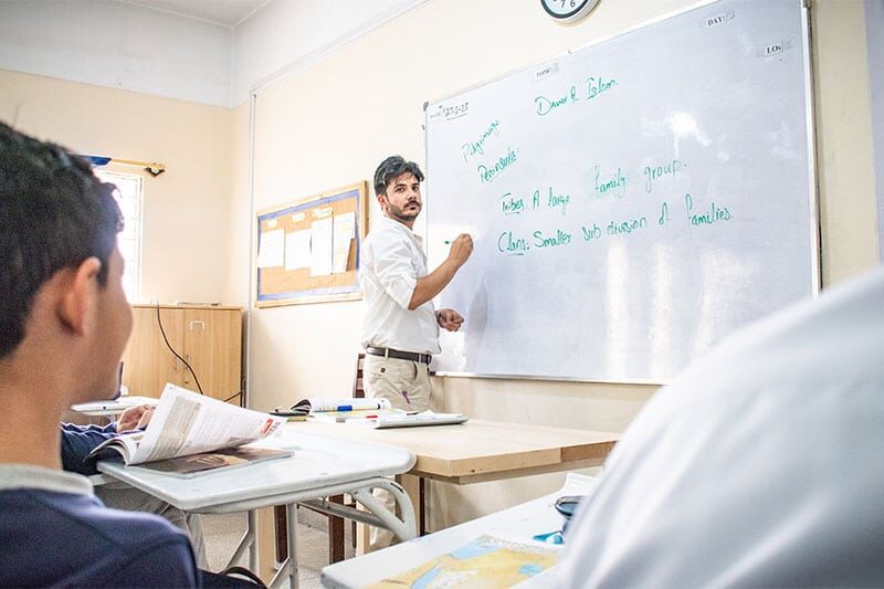 Teacher writing on the whiteboard during a classroom lecture at Beaconhouse