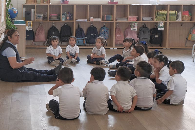 Teacher leading a circle time session with young children in a classroom
