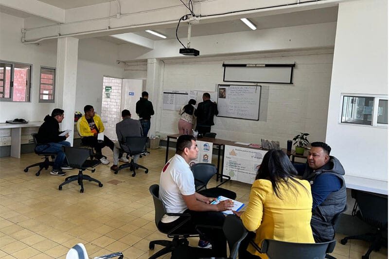Parents and staff collaborating in a workshop setting inside the school