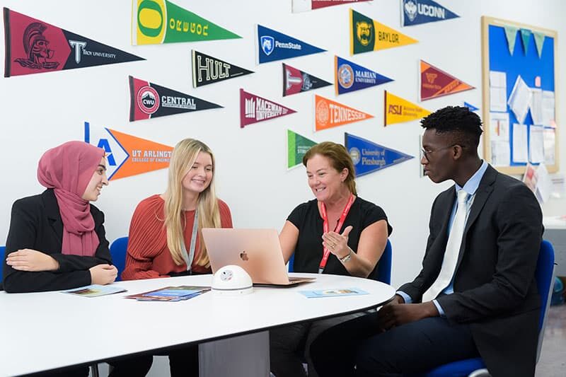 College counselor meeting with senior students in a university guidance room