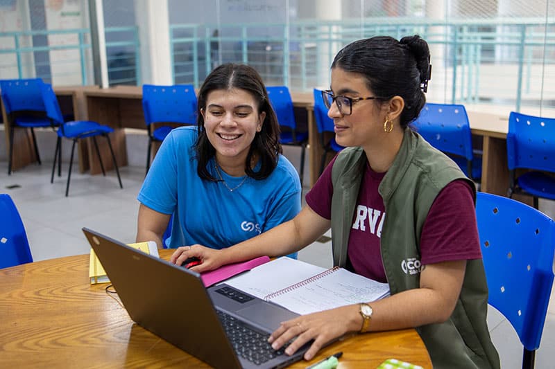 Two students at Escola COC São Luís working on a laptop as part of their digital literacy program.