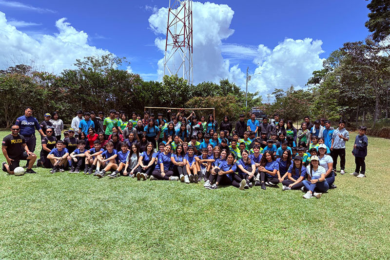 Large group of students and police officers gathered outdoors for a school event at Escuela y Colegio Científico Interamericano