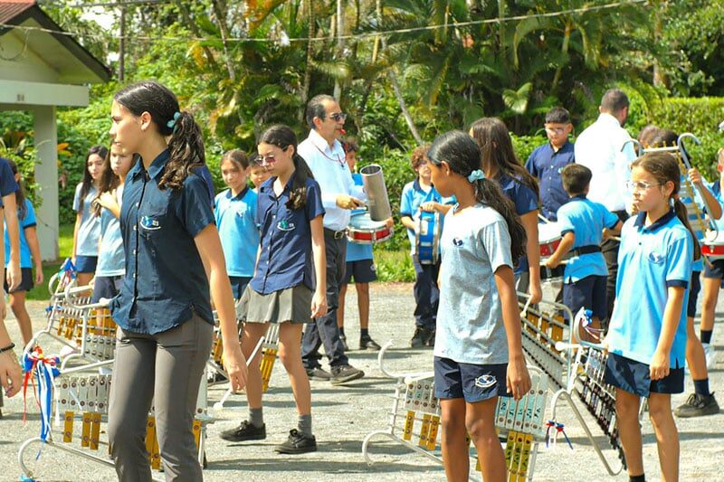 Students rehearsing with percussion instruments during a school band practice at Escuela y Colegio Científico Interamericano
