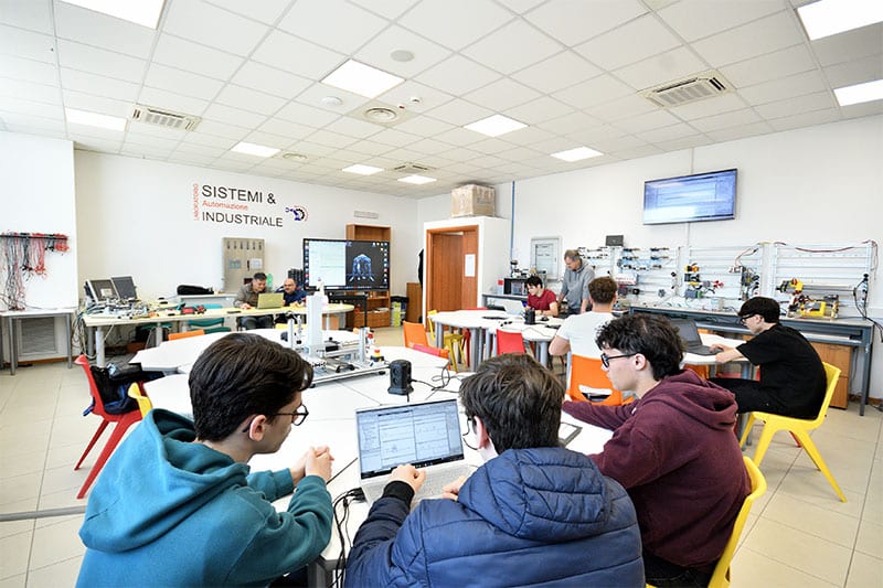 Students working on industrial automation projects in a classroom lab