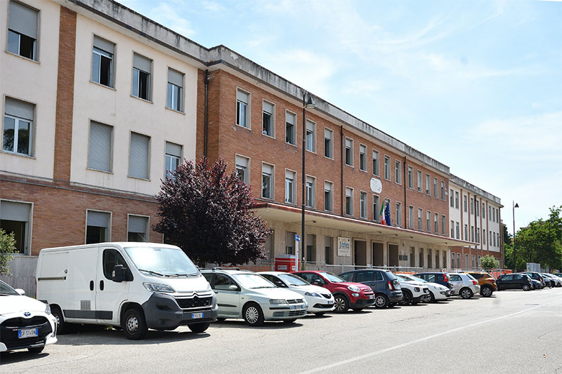 Exterior view of a technical institute with parked cars in front