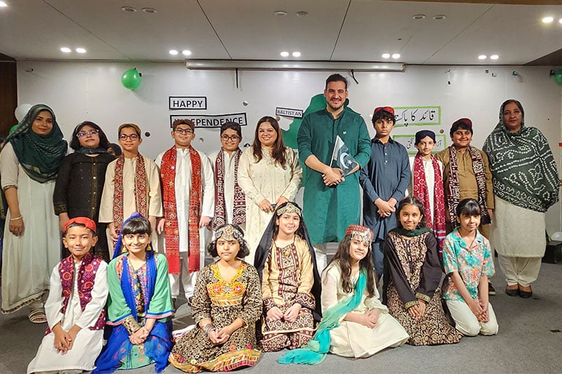 Students and teachers in traditional Pakistani dress celebrating Independence Day