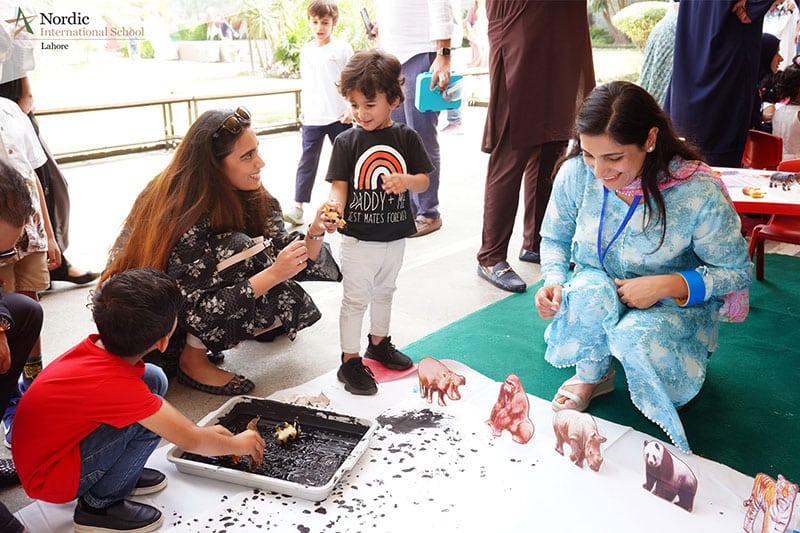 Parents and children participating in an interactive learning activity outdoors