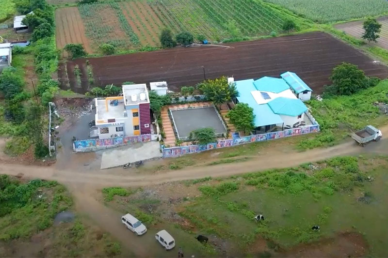 Aerial view of The School Jalindarnagar surrounded by farmland and greenery