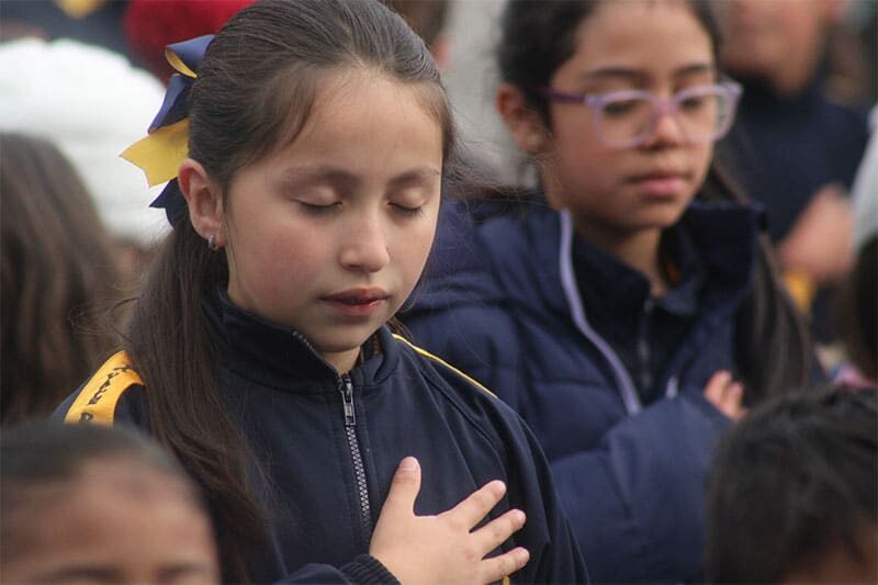 Student with hand on heart during a moment of reflection and respect