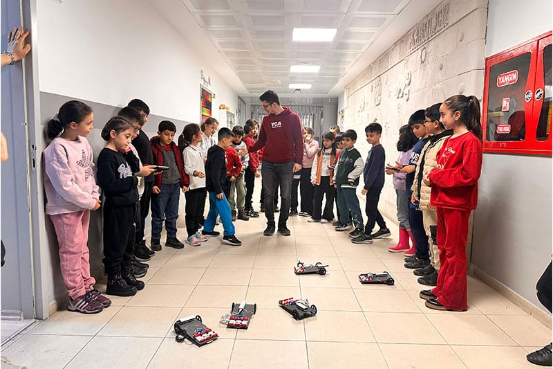 Students at Diyarbakir Science and Art Center participating in a hallway robotics activity with small programmable vehicles
