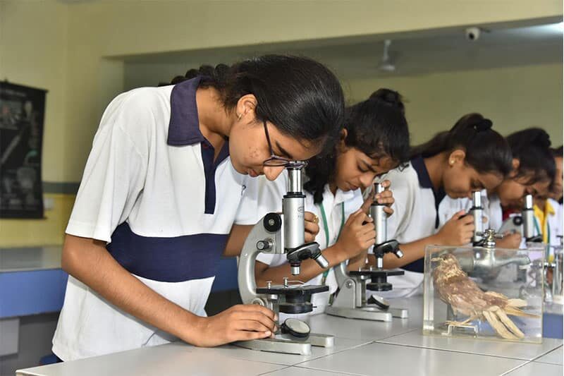 Students using microscopes during a biology class