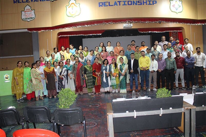 Group photo of faculty and staff at Delhi Public School Varanasi auditorium