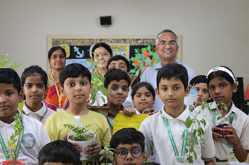 Primary students holding saplings during an environment-focused activity