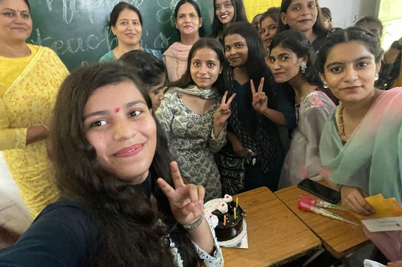 Students and teachers from GGSSS NIT 5 taking a celebratory selfie in a classroom