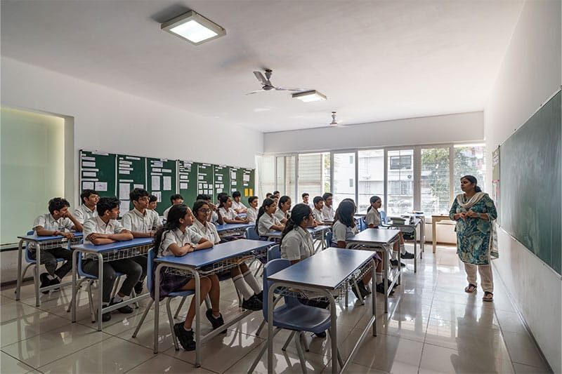 Teacher instructing a classroom of attentive Ekya students in a modern academic setting