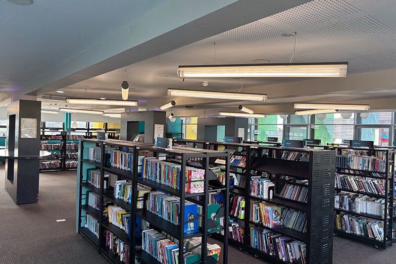 Interior view of the Rivers Academy West London library with book shelves and reading spaces
