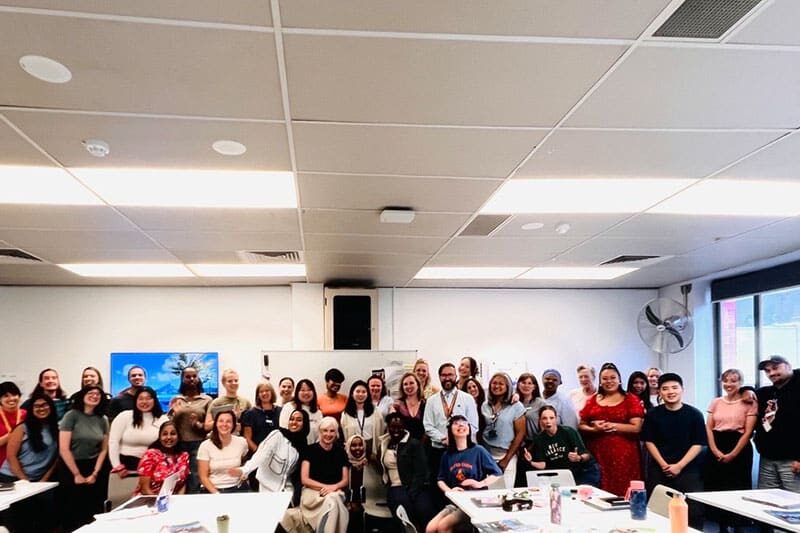 Large group of people gathered in a classroom setting for a workshop or training session