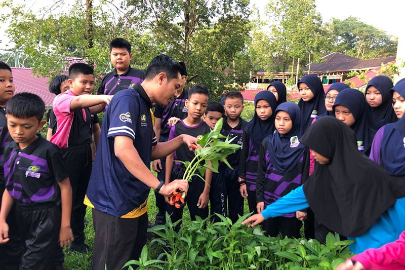 Students at SK Putrajaya Presint 11(1) participate in a school garden activity with their teacher