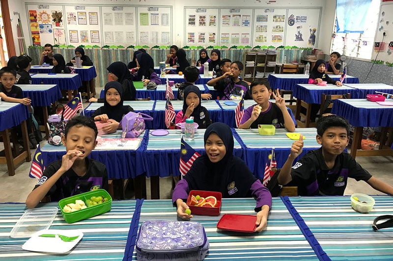 SK Putrajaya Presint 11(1) students enjoy healthy meals in a classroom decorated for a national celebration