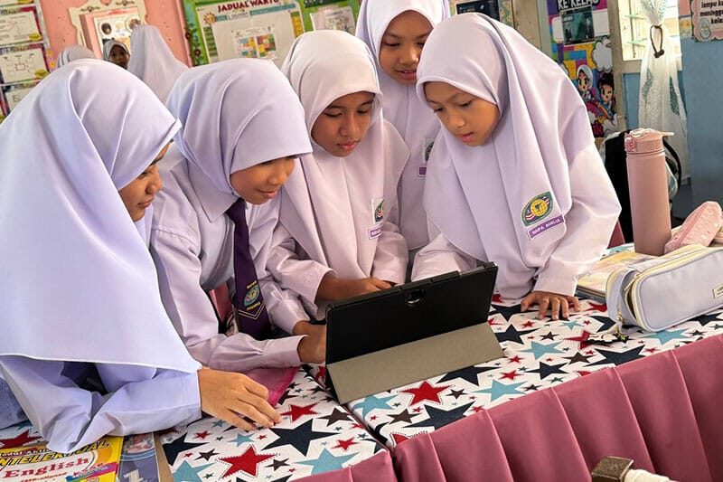 Female students at SK Putrajaya Presint 11(1) using a tablet as part of the HELPIE wellbeing project