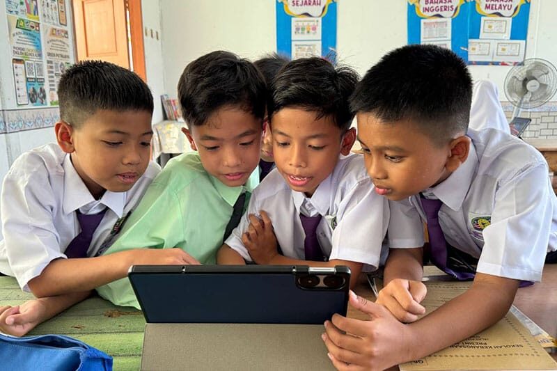 Male students at SK Putrajaya Presint 11(1) using a tablet to explore mental wellbeing resources