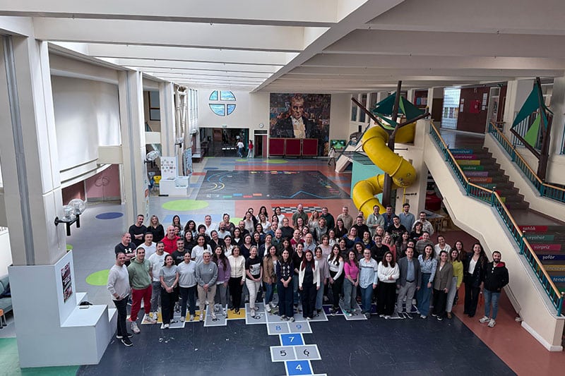 Group photo of VKV Koç Özel Okulu staff in the school's vibrant atrium