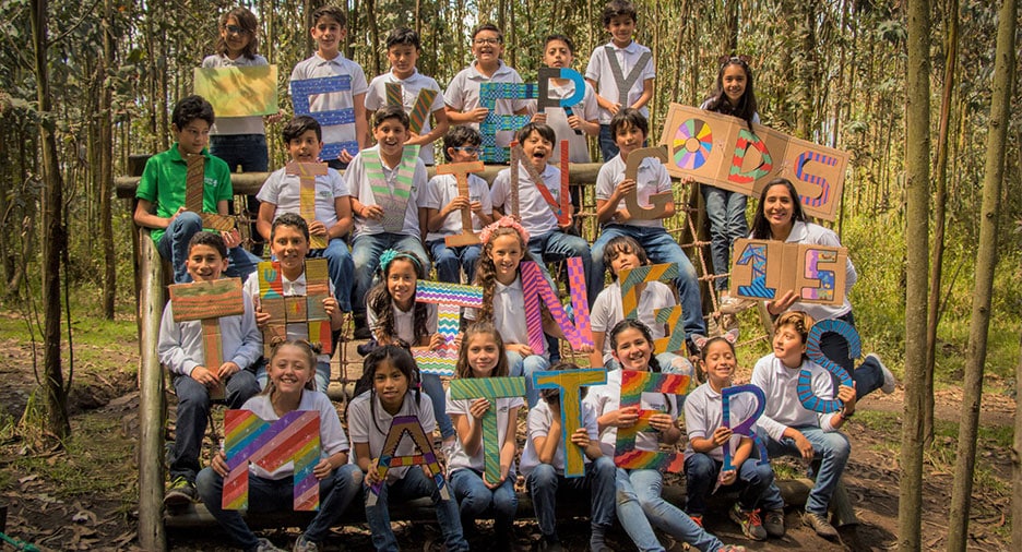 Group of children outdoors holding colorful signs that spell out 'Everything Matters'
