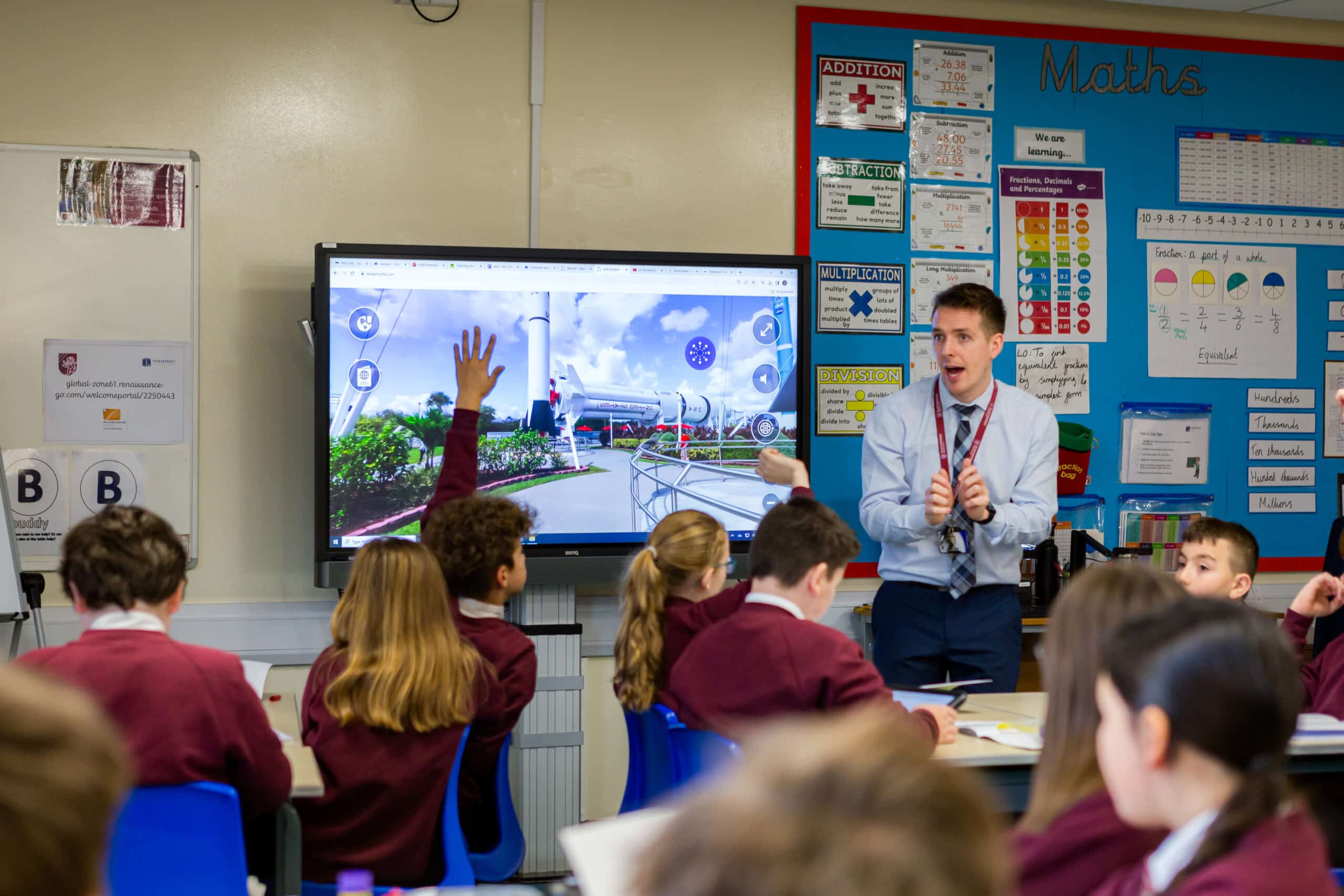 Teacher Engaging Students in Interactive Lesson with Digital Display and Visual Content