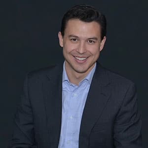 Professional Portrait of Smiling Man in Dark Suit and Light Blue Shirt