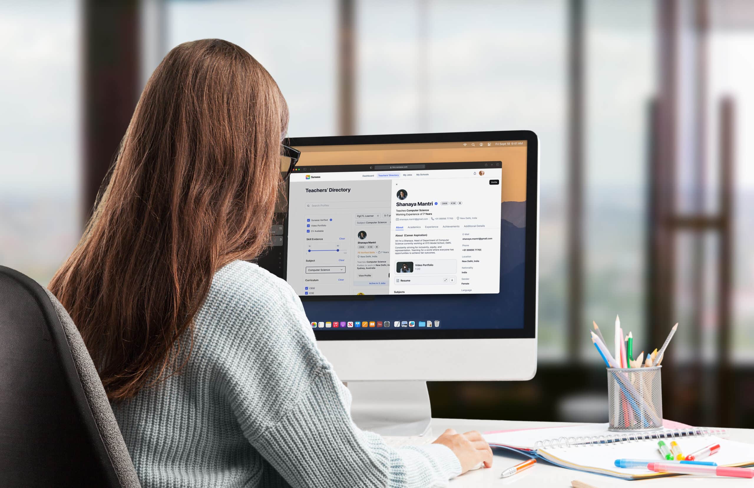 Woman using desktop computer to view teacher directory on an educational platform