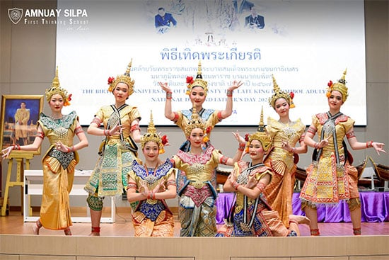Traditional Thai dance performance by students at school event Students in traditional Thai costumes performing a cultural dance on stage during a school celebration.