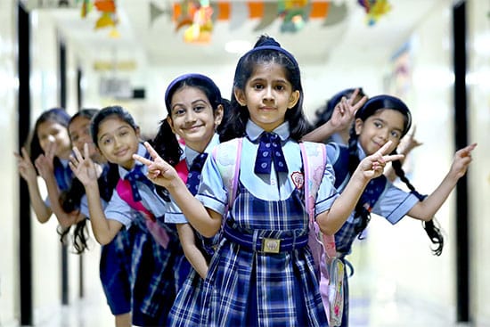 Schoolgirls having fun in the school corridor Group of young schoolgirls posing for a photo in a hallway with a playful and cheerful expression