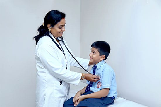 Paediatric check-up with a doctor using a stethoscope on a boy Doctor examining a young boy with a stethoscope during a check-up