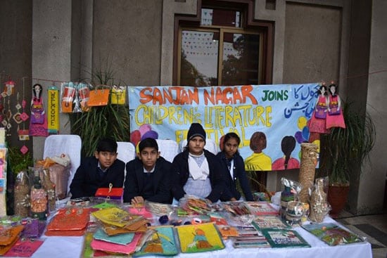 School children displaying handmade crafts and books at a stall during the Children’s Literature Festival.