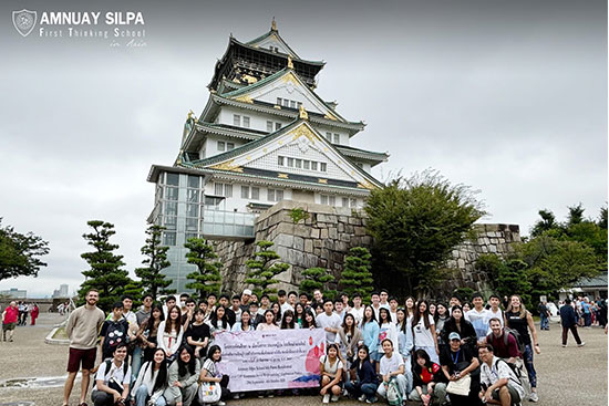 Students visit Osaka Castle on international school trip to Japan Large group of students posing with a banner in front of Osaka Castle during an international school trip to Japan.