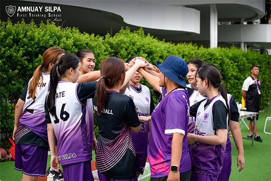 U18 girls’ team prepares with huddle before school sports match School girls in purple sports uniforms huddling together before a game during a sports event.