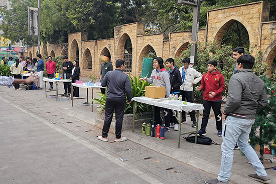 Students setting up stalls and interacting with visitors during a school street exhibition.