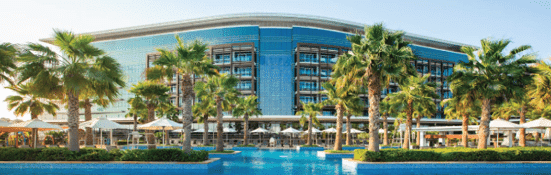 Marriott Al Forsan Resort with a large swimming pool and palm trees in the foreground.