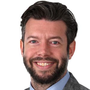 Headshot of Alex Gray, smiling man in a suit and tie
